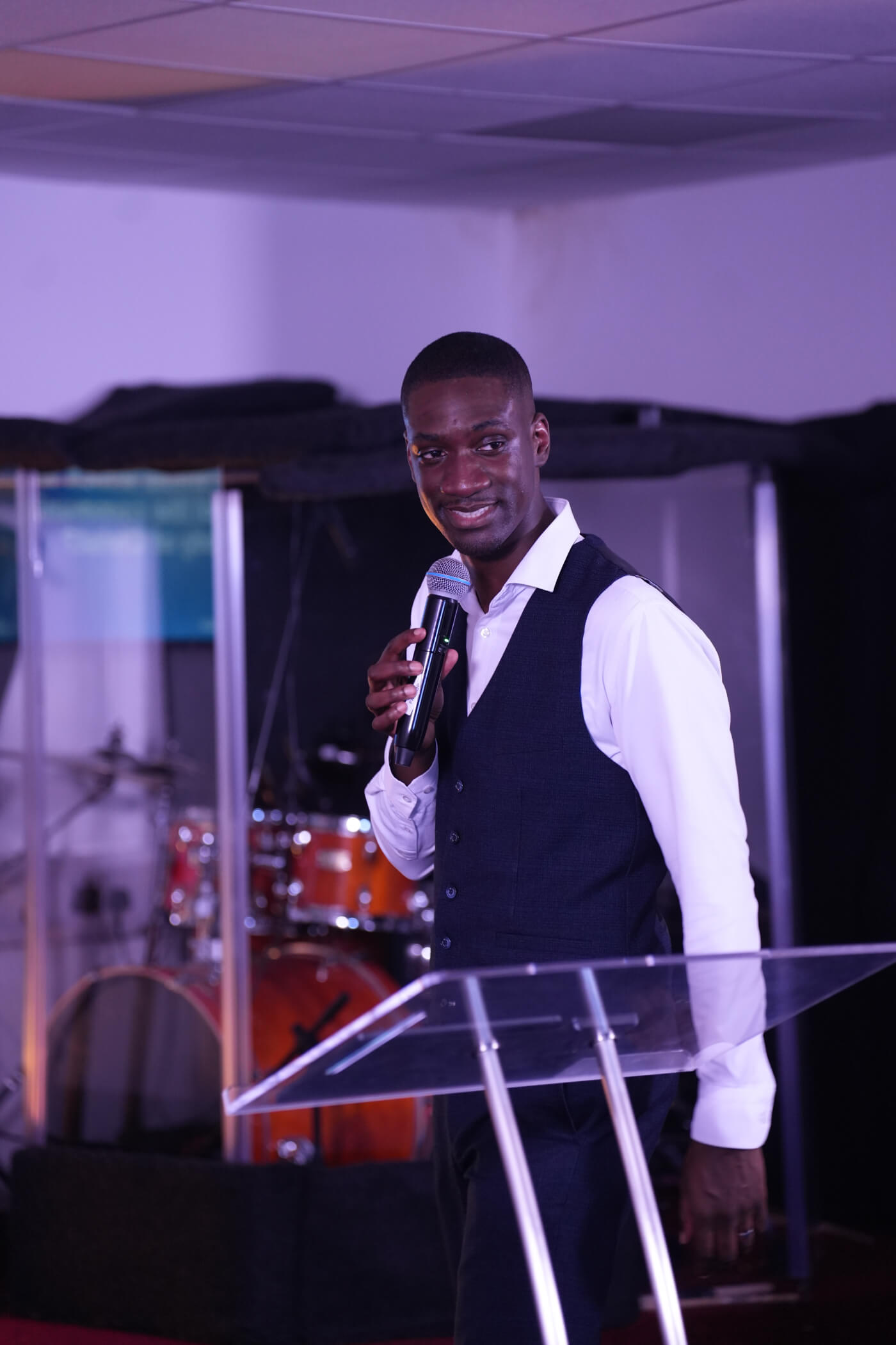A speaker smiling at the congregation, microphone in hand